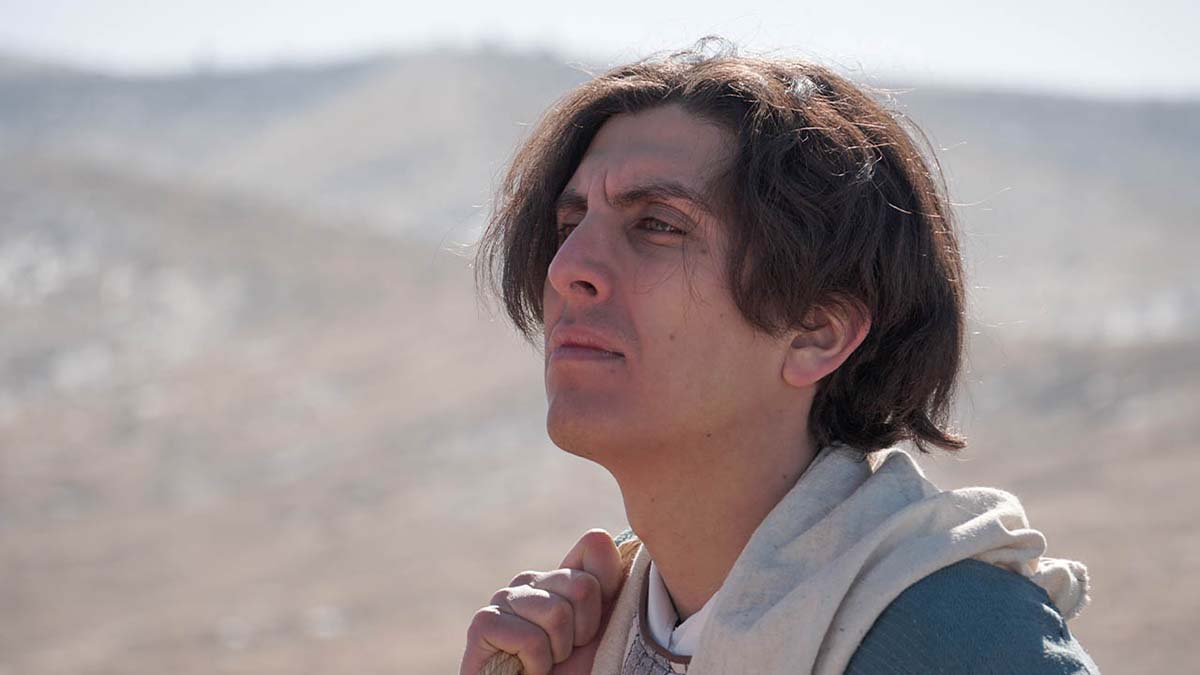 Sean Acebal as Isaac looks up the mountain during a travel scene.