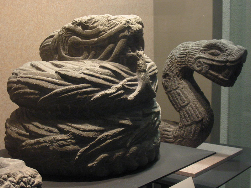 Stone sculptures of feathered serpents. Photo by Thelmadatter via Wikimedia Commons.