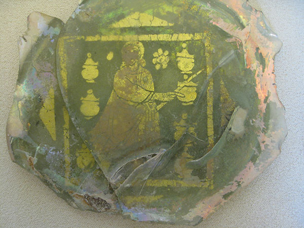 A gold-leafed glass plate of Jesus changing water into wine with a wand. Photo by John W. Welch.