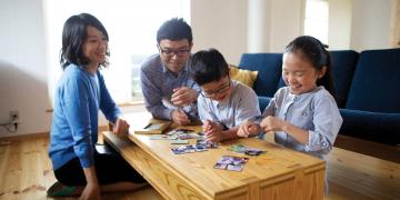 An image of a family in Japan looking at family photos on a coffee table
